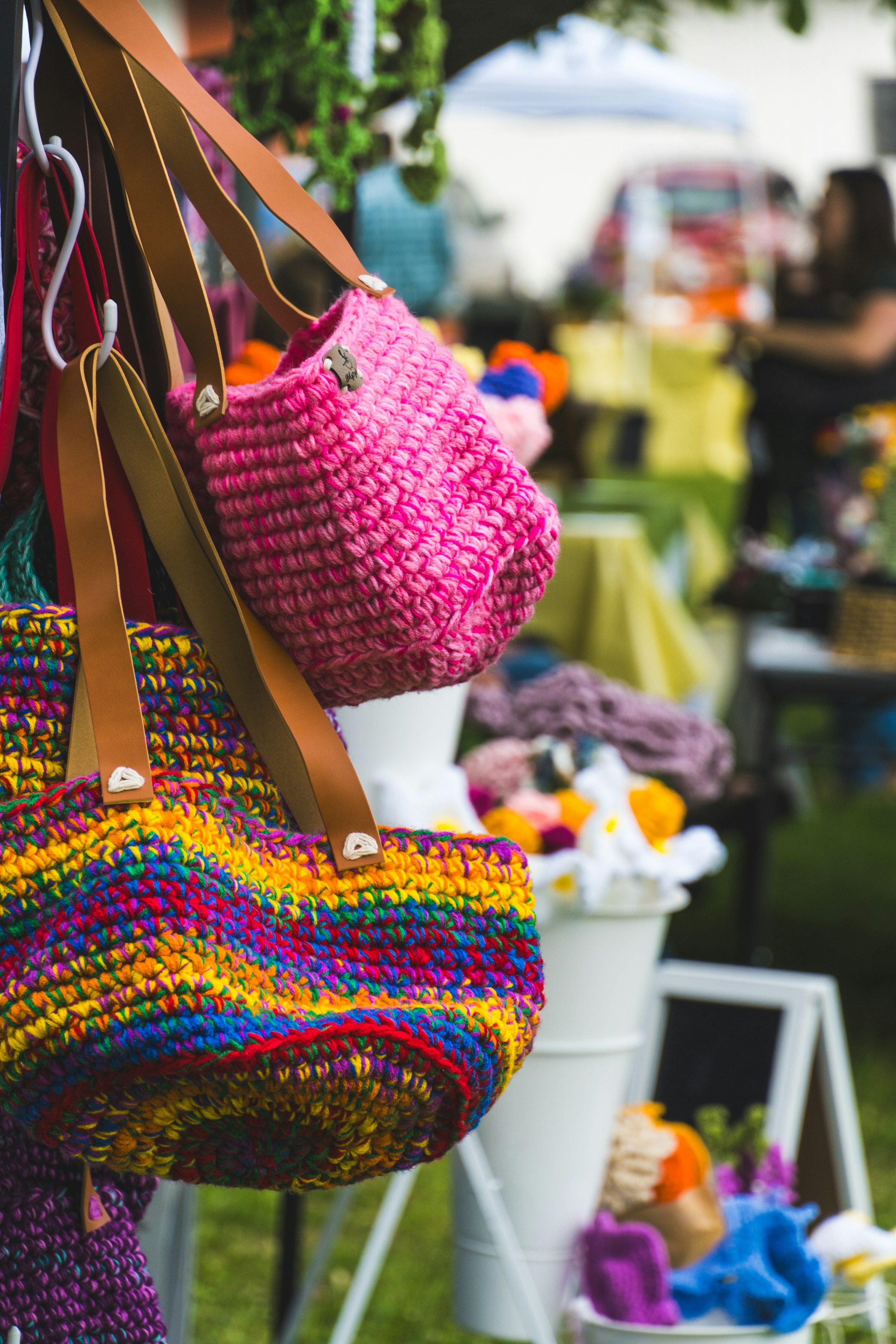 Handmade crochet bags displayed together at a market